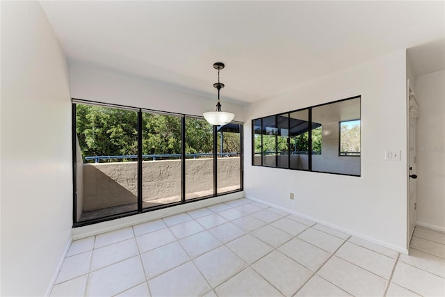 spare room featuring light tile patterned floors and baseboards