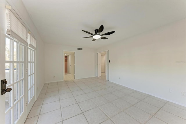 empty room with visible vents, baseboards, ceiling fan, and light tile patterned flooring