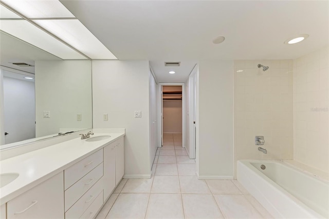 bathroom with baseboards, double vanity, a sink, tile patterned floors, and shower / bathtub combination