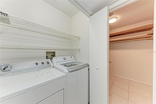 laundry area with laundry area, light tile patterned floors, baseboards, and independent washer and dryer