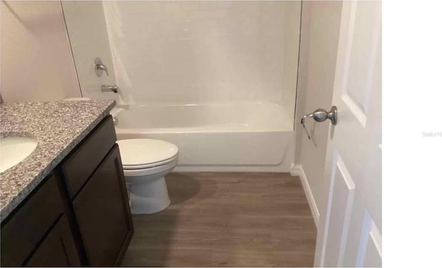 bathroom with toilet, vanity, bathing tub / shower combination, and wood finished floors