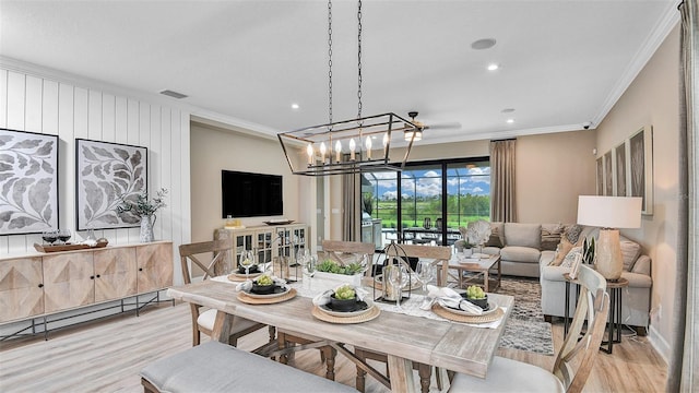 dining area featuring visible vents, crown molding, light wood-style floors, and a baseboard radiator