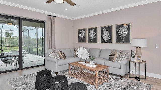 living area with ceiling fan, baseboards, a sunroom, ornamental molding, and wood finished floors