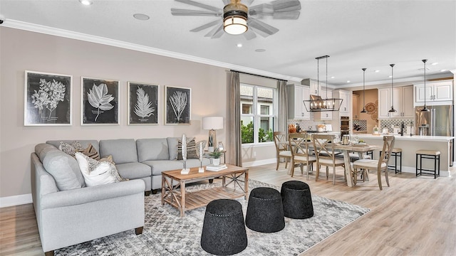 living area featuring light wood-style floors and crown molding