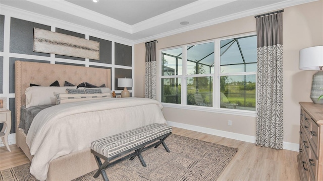 bedroom featuring light wood-style flooring, crown molding, and baseboards