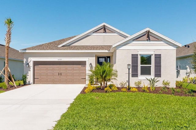 view of front of property with stucco siding, a front lawn, concrete driveway, and an attached garage