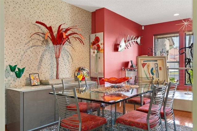 dining area with plenty of natural light, a textured ceiling, and wood finished floors