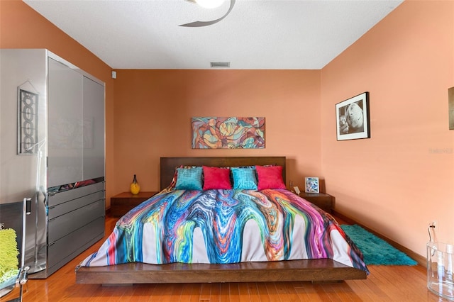 bedroom with wood finished floors and visible vents