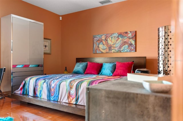 bedroom with wood finished floors and visible vents