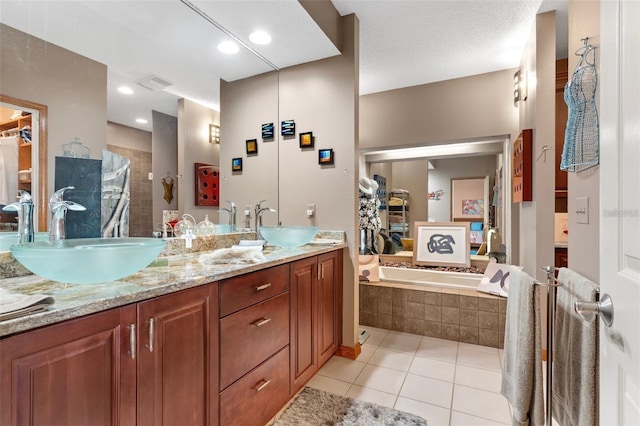 full bathroom with tile patterned flooring, double vanity, a bath, and a sink