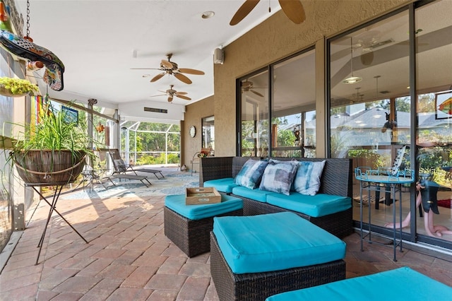 view of patio / terrace with glass enclosure, an outdoor hangout area, and a ceiling fan