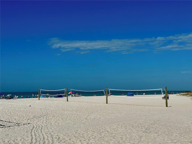 view of property's community featuring volleyball court, a beach view, and a water view