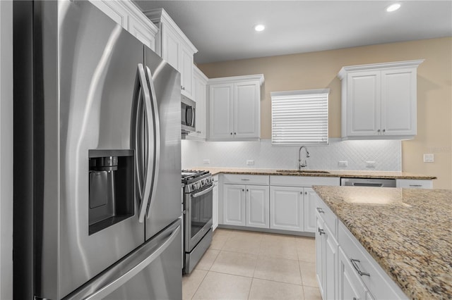 kitchen featuring a sink, white cabinets, light tile patterned flooring, and stainless steel appliances