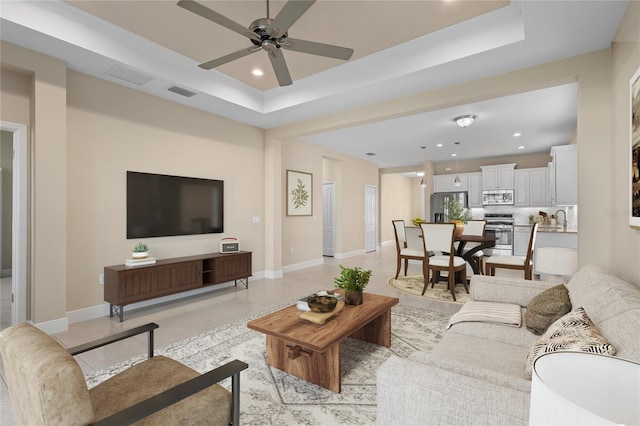 living room featuring visible vents, recessed lighting, baseboards, light tile patterned flooring, and a raised ceiling