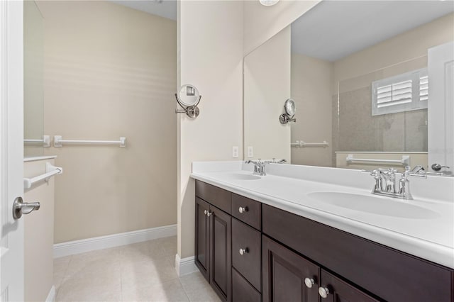 full bathroom featuring a sink, baseboards, double vanity, and tile patterned flooring