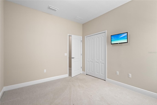 unfurnished bedroom featuring a closet, visible vents, carpet flooring, and baseboards