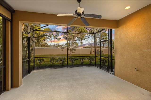 unfurnished sunroom featuring ceiling fan