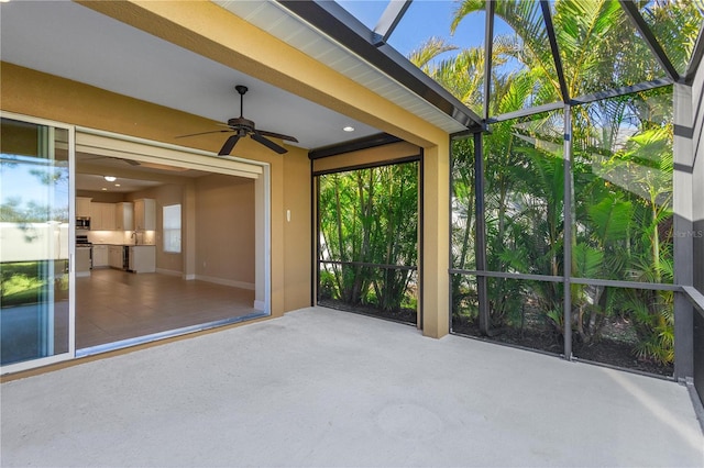unfurnished sunroom featuring a ceiling fan