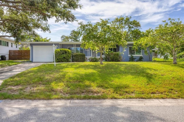 view of front of house with concrete driveway, a garage, and a front lawn