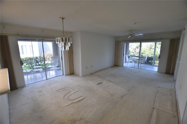 empty room with ceiling fan with notable chandelier