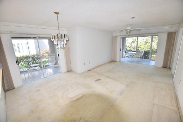 empty room featuring a textured ceiling, a healthy amount of sunlight, and ceiling fan with notable chandelier