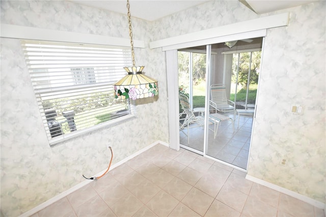 unfurnished dining area with tile patterned floors and baseboards