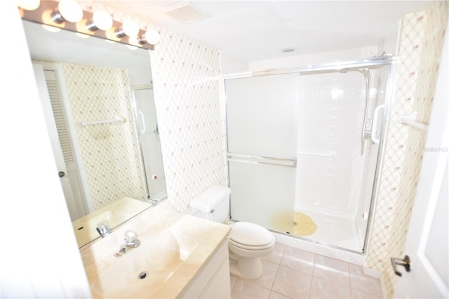 bathroom with tile patterned flooring, a stall shower, toilet, and vanity