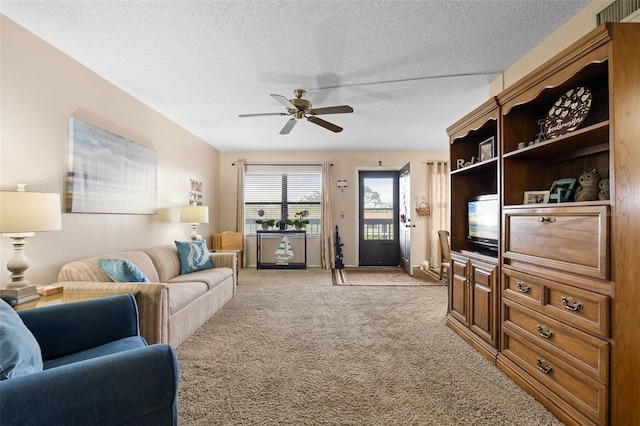 living area featuring a ceiling fan, light colored carpet, and a textured ceiling