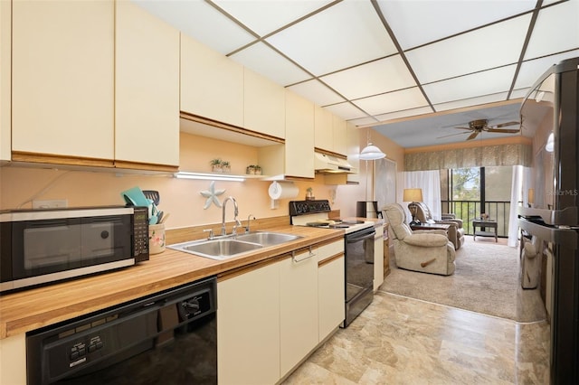 kitchen featuring a sink, butcher block countertops, range with electric cooktop, black dishwasher, and stainless steel microwave