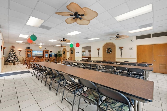 dining room with a drop ceiling and light tile patterned flooring