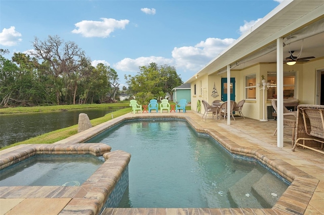 view of pool with a patio area, a water view, a pool with connected hot tub, and ceiling fan