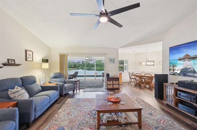 living area featuring a textured ceiling, wood finished floors, a ceiling fan, and vaulted ceiling