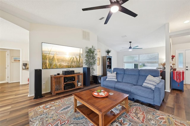 living room featuring visible vents, baseboards, wood finished floors, and vaulted ceiling