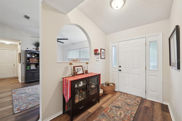 entryway featuring visible vents, ceiling fan, baseboards, wood finished floors, and a textured ceiling