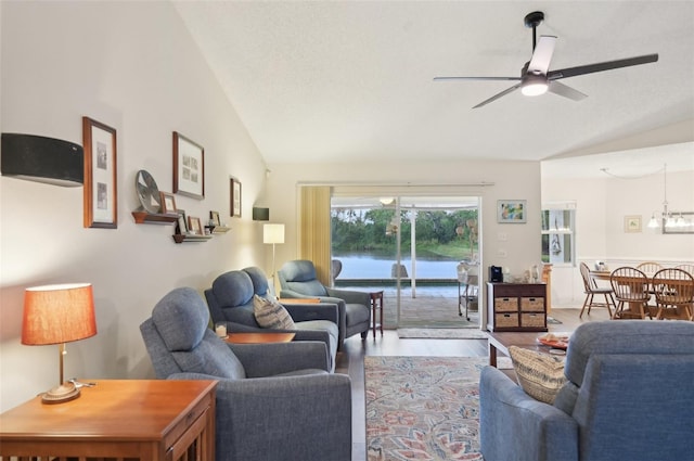 living room featuring wood finished floors, a ceiling fan, vaulted ceiling, a water view, and a textured ceiling