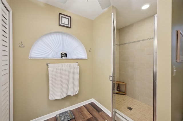 bathroom featuring recessed lighting, baseboards, wood finished floors, and a shower stall