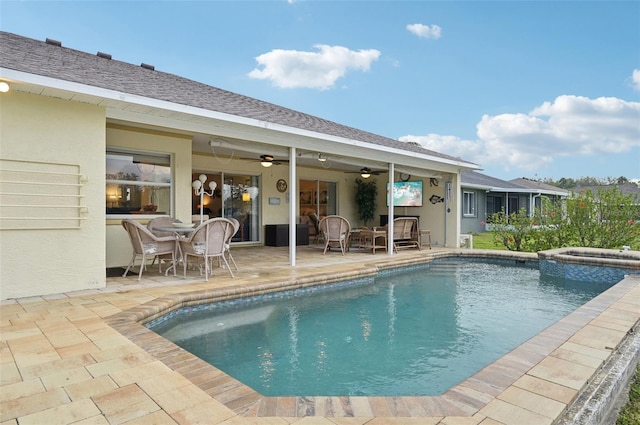 view of pool with a patio area, outdoor dining space, a pool with connected hot tub, and ceiling fan