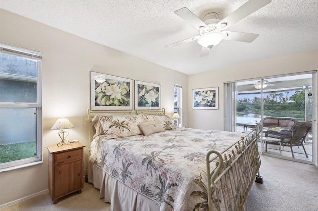 bedroom featuring a textured ceiling, access to exterior, a ceiling fan, and light carpet