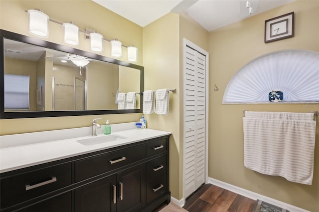 bathroom with visible vents, baseboards, a stall shower, wood finished floors, and vanity