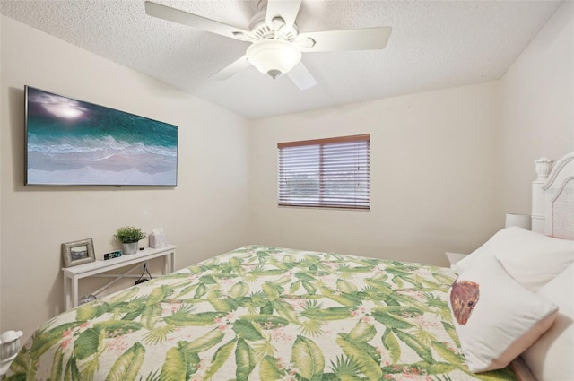 bedroom with ceiling fan and a textured ceiling