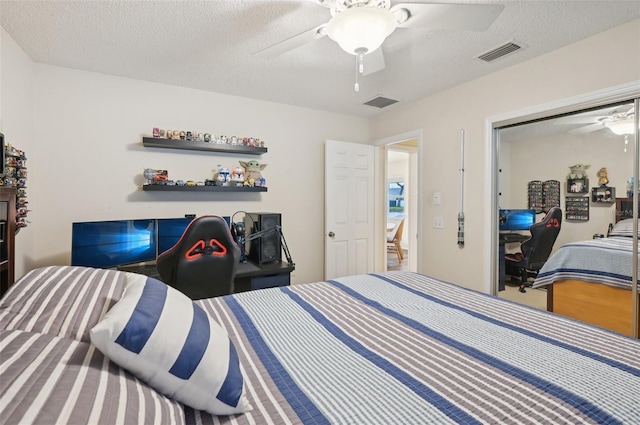 bedroom featuring visible vents, a textured ceiling, and a ceiling fan