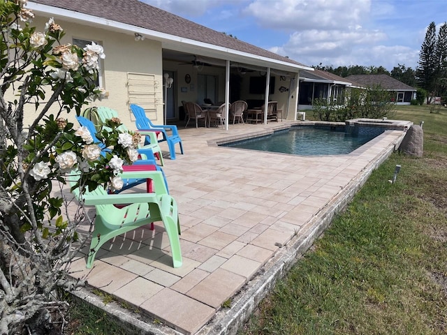 outdoor pool with ceiling fan, a patio area, a yard, and outdoor dining space