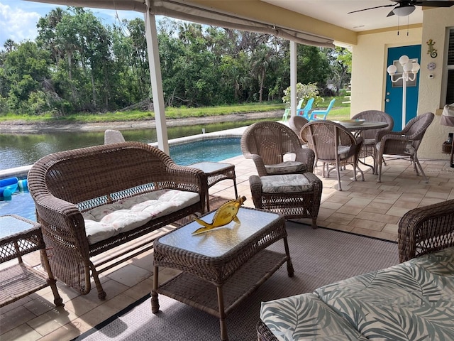 exterior space with a water view, a ceiling fan, and an outdoor pool