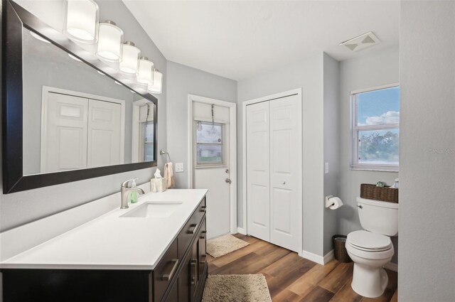 3419 31st St E, Bradenton, FL 34208 - bathroom with a closet, vanity, toilet, wood finished floors, and baseboards