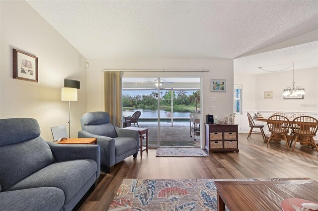 3419 31st St E, Bradenton, FL 34208 - living area with lofted ceiling, dark wood-style floors, a textured ceiling, a chandelier, and a water view