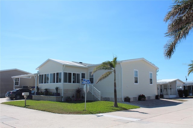 view of front of house featuring crawl space, driveway, a front yard, and a sunroom