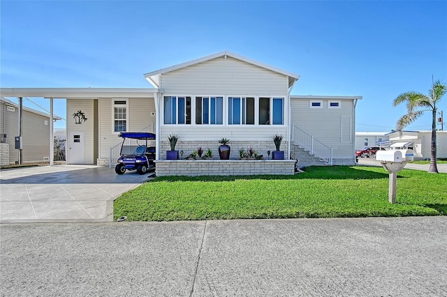 manufactured / mobile home featuring driveway and a front lawn