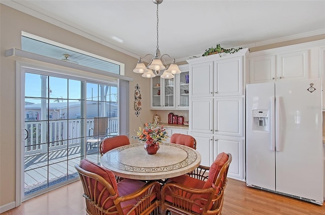 dining area featuring an inviting chandelier, light wood-style floors, and ornamental molding