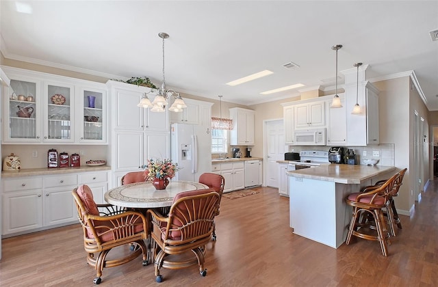 kitchen with white cabinetry, white appliances, light wood-type flooring, and a sink