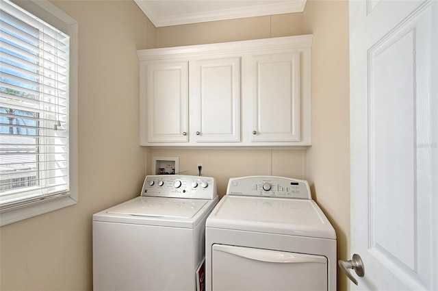 washroom featuring cabinet space, washing machine and dryer, and crown molding